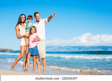 Happy Mixed Race Family Of Four Playing On The Beach