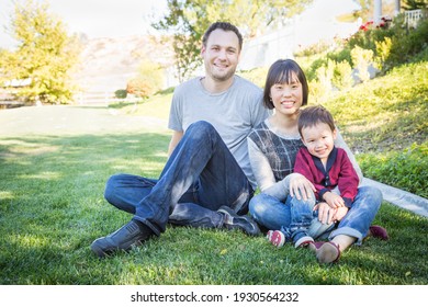 Happy Mixed Race Family Having Fun Outside On The Grass.