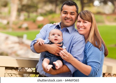 Happy Mixed Race Family Posing for A Portrait in the Park.