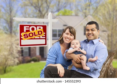 Happy Mixed Race Young Family In Front Of Sold Home For Sale Real Estate Sign And House.