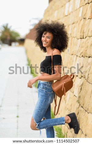 Similar – Fröhliche gemischte Frau mit Afrohaar, die im Freien steht.