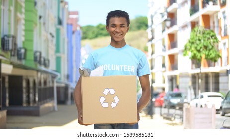 Happy Mixed-race Teen Male Eco-volunteer Holding Paper Box With Recycling Sign