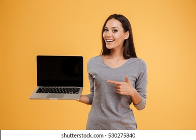 Happy model with laptop in studio. isolated orange background - Shutterstock ID 530275840
