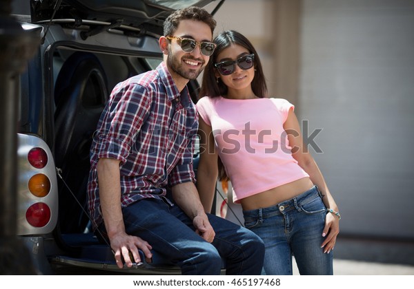 Happy model man and woman posing near car.\
Models posing for photographer. Fashion or vogue concept. Fashion\
or vogue magazine.