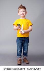 Happy Modern Kid Playing With Toy Airplane And Car. Studio Shot