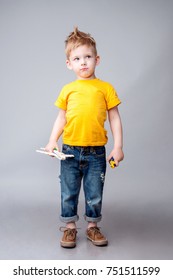 Happy Modern Kid Playing With Toy Airplane Nd Car. Studio Shot