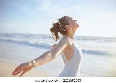 happy modern woman in white swimsuit at the beach relaxing. - Powered by Shutterstock