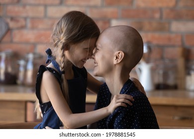 Happy Mom With Cancer And Positive Little Daughter Girl In Apron Cooking Together In Kitchen, Hugging And Smiling. Oncology Female Patient Spending Leisure Time With Kid. Cancer, Family Concept