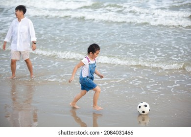 Happy Mom And Daughter Having Fun Playing Soccer On The Beach. Happy Family Having Fun Running On Beach. Relaxing Holiday Concept. Travel Attention