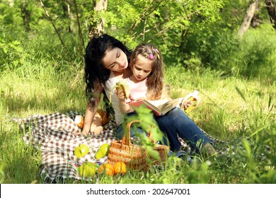 Happy Mom And Daughter. Picnic In The Green Park