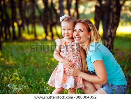 Happy mom and daughter smiling at nature. 
