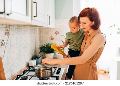 Happy Mom With Her Child Cooking At The Kitchen. Cozy Home And Routine Duties