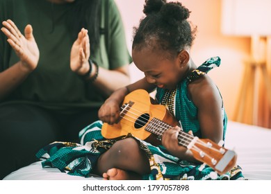 Happy Mom With Her Daughter Playing Guitar And Singing Together At Home, Happy Family