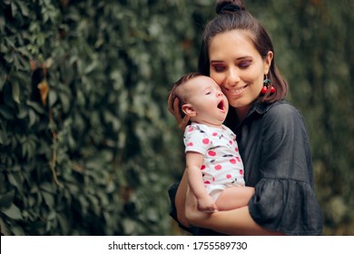 Happy Mom Holding Funny Sleepy Yawning Baby. Cool Trendy Mom Spending Quality Time Outdoors With Her Daughter
