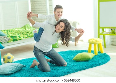 Happy Mom Plays With Her Son At Home