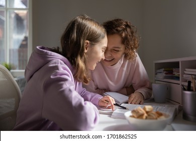 Happy Mom And Teenage Daughter Having Fun Studying Together At Home. Cheerful Adult Parent Mother Helping Teen School Child Student Doing Homework, Talking, Laughing, Sitting At Home Desk In Sunny