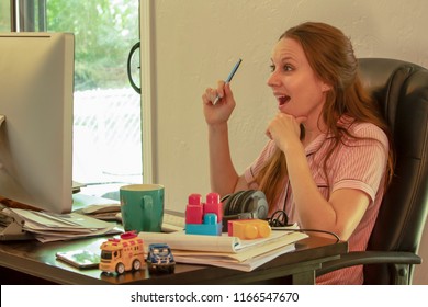 Happy Mom Wearing Pajamas Looking At Computer Toys Coffee On Messy Desk, Mobile Career Work From Home Lifestyle Home Based Business Concept Freedom Fun Fulfilled Concept Aha Moment