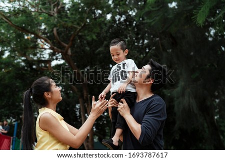 Happy moment of the family, the little boy sitting on dad's shoulder and mom teasing him.