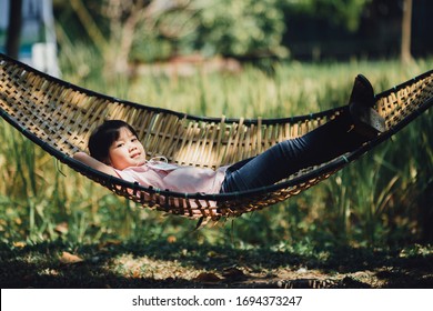 Happy moment at home of little kids feeling relax on platform tree swing (hammock). Concept for happiness in children with natural environment. Portraits of families at home enjoying simpl - Shutterstock ID 1694373247