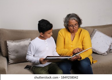 Happy Moments With Grandma, Indian/asian Senior Lady Spending Quality Time With Her Grand Son Reading Book Together.