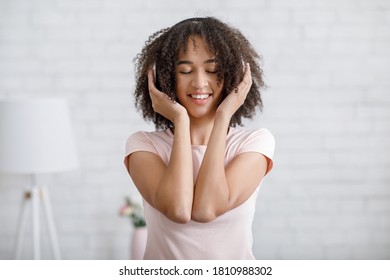 Happy Moments With Music At Home. African American Woman With Closed Eyes And Headphones In Living Room Interior, Copy Space