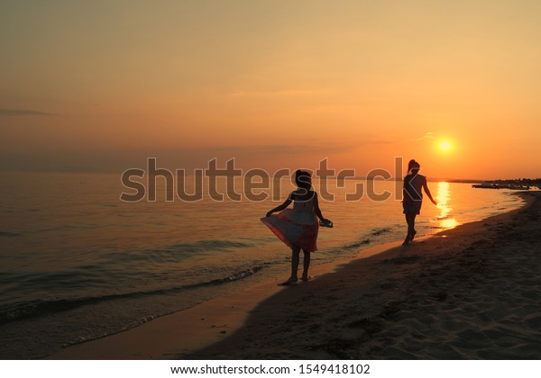 Happy moments of\
people on the beach at\
sunset