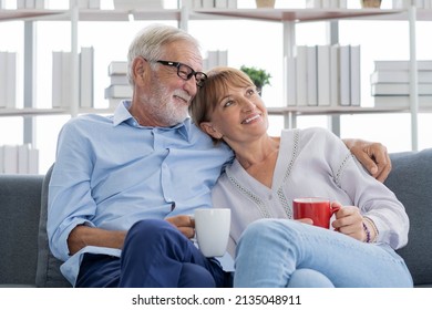 Happy Morning, Caucasians Senior Lover Couple Family. Mature, Adult Retired Man, Woman Drinking Coffee, Tea Together, Embracing, Hugging On Sofa, Couch At Home. Pleasure Husband And Wife Lifestyle.