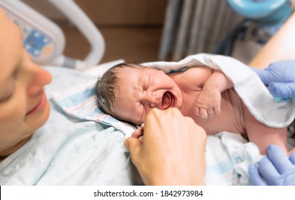 Happy mother after delivery holding her newborn baby girl for the first time. New life concept. 
 - Shutterstock ID 1842973984
