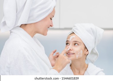 Happy Mother Applies On Face Her Daughter Wash Foam In The Bathroom At Home