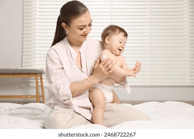 Happy mother applying body cream onto baby`s skin at home - Powered by Shutterstock