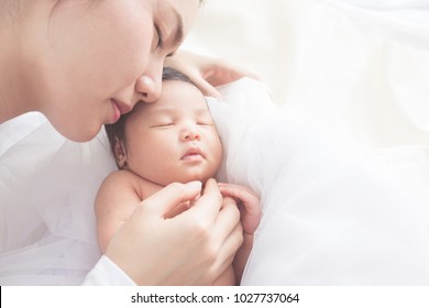 Happy Mother With Baby In Bed