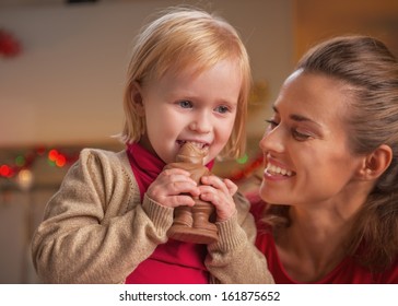 Happy Mother And Baby Eating Chocolate Santa