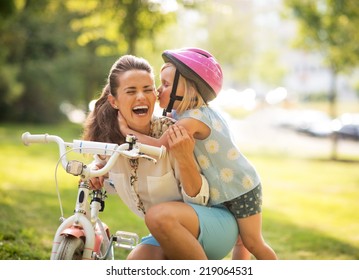 Happy Mother And Baby Girl Having Fun In Park With Bicycle