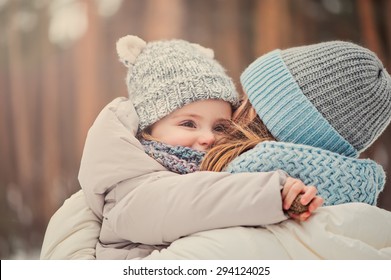 Happy Mother And Baby Girl On The Walk In Winter Snowy Forest