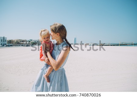 Happy mother and baby girl on the Kite beach in Dubai