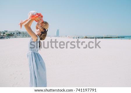 Happy mother and baby girl on the Kite beach in Dubai