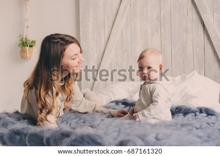 Foto Bild glückliche Mutter und Baby, die zu Hause im Schlafzimmer spielen.