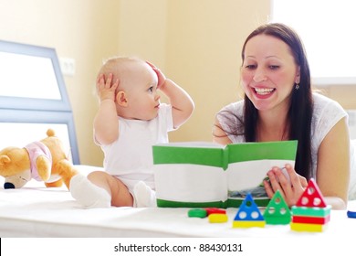 Happy Mother With Baby Reading Book