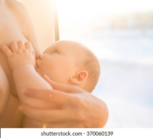 Happy Mother Breast Feeding Her Baby Infant. Mom Nursing Baby. Woman And New Born Boy Relax. Mother Breast Feeding Baby. Family At Home