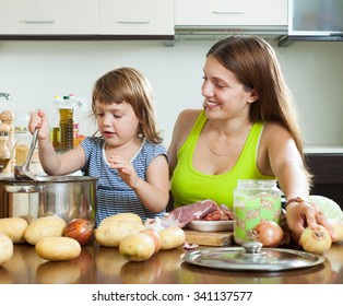 Happy Mother With Child Cooking Soup