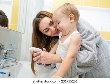 Happy Mother And Child Washing Hands With Soap Together In Bathroom