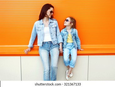 Happy Mother And Child Wearing A Jeans Clothes In City