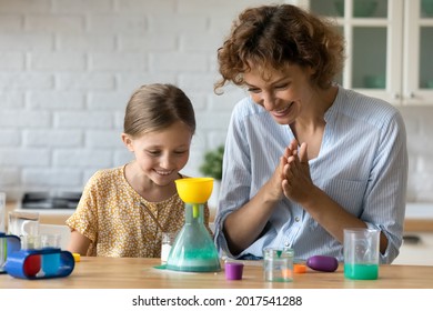 Happy mother and curious little daughter having fun with toy laboratory at home, smiling mom with adorable kid girl making funny experiments together, engaged in educational activity in kitchen - Powered by Shutterstock