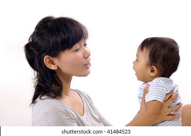 Happy mother with cute baby girl in the studio. Mother teaching the baby to talk
