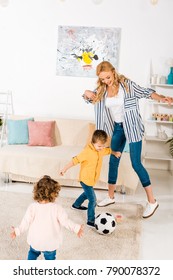 Happy Mother And Cute Little Kids Playing With Soccer Ball At Home