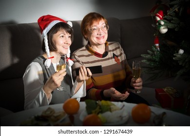 Happy Mother And Daughter Drink Champagne And Watch TV On Christmas Night