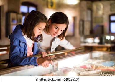 Happy mother and daughter exploring expositions of previous centuries in museum - Shutterstock ID 648326134