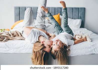 Happy mother and daughter having fun and playing together on the bed at home.  - Powered by Shutterstock