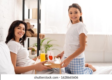 Happy Mother And Daughter Holding Tray With Breakfast, Mothers Day Card With Heart Sign And Mom Lettering