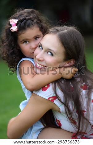 Happy mother and daughter laughing together outdoors 